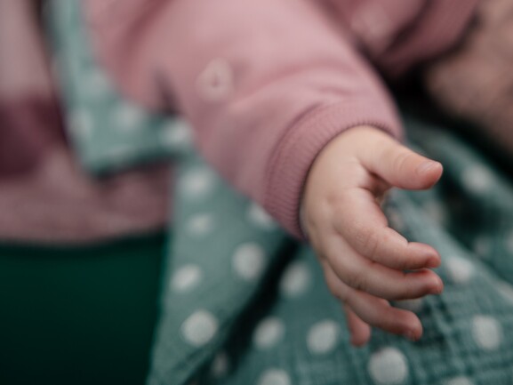 Babykurs Kleine Entdecker im SGZ Essen-Dellwig Babyhand greift nach einem gepunkteten Tuch – Babykurs Kleine Entdecker für Babys von 3 bis 9 Monaten in Essen-Dellwig